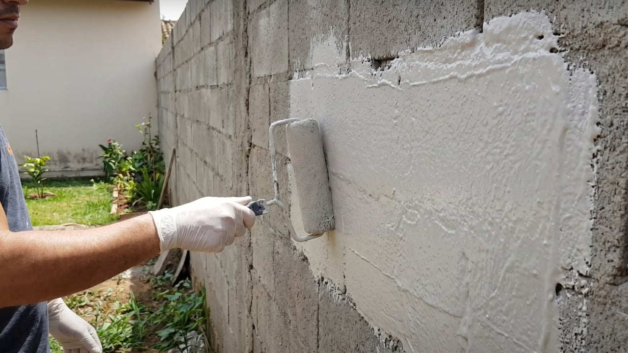 Homem aplicando tinta emborrachada na área externa da casa