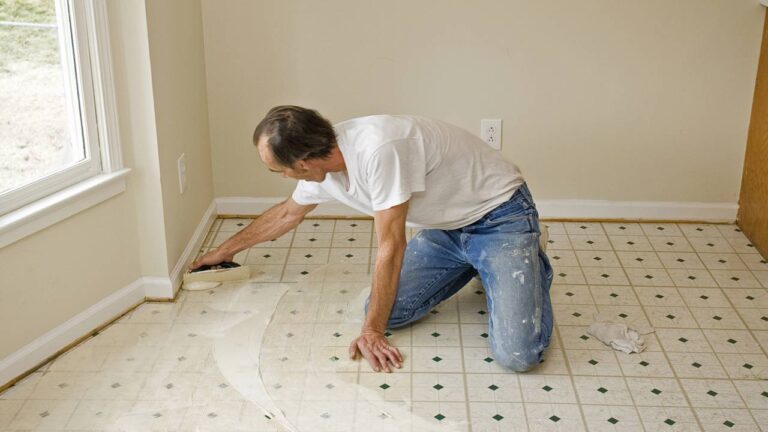 Homem instalando piso vinílico em casa