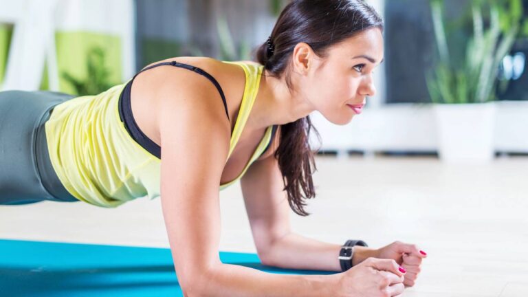Mulher fazendo prancha abdominal em tapete