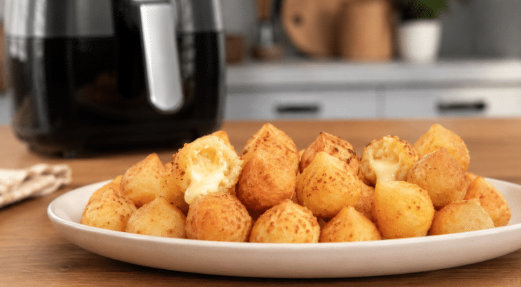 Mini coxinhas de batata feitas na Air Fryer, douradas e servidas em travessa para petiscar sem fritura.